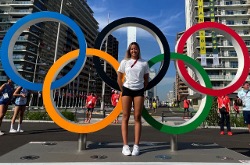 在东京的奥运戒指前的Gaurika singh。塔夫茨第一年学生Gaurika Singh在尼泊尔的游泳队上，并在开幕式上携带了她的国家旗帜。