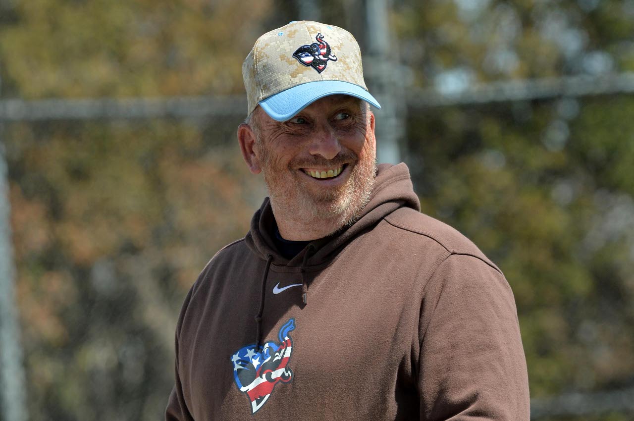 约翰·凯西戴着一顶巨型棒球帽。凯西领导了全国知名的塔夫茨棒球项目40多年，即将退休